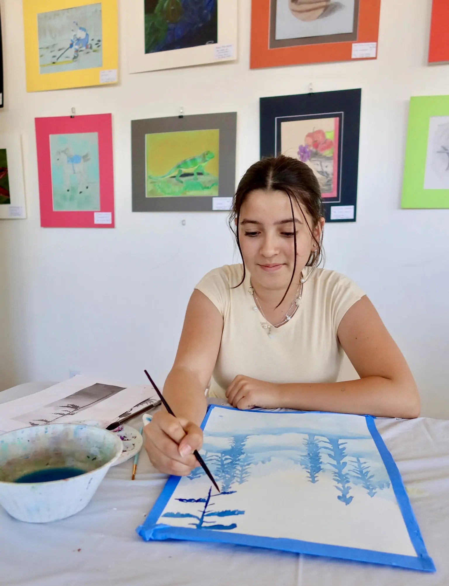 Teen art student painting a nature scene during class at Aliki’s Art House.
